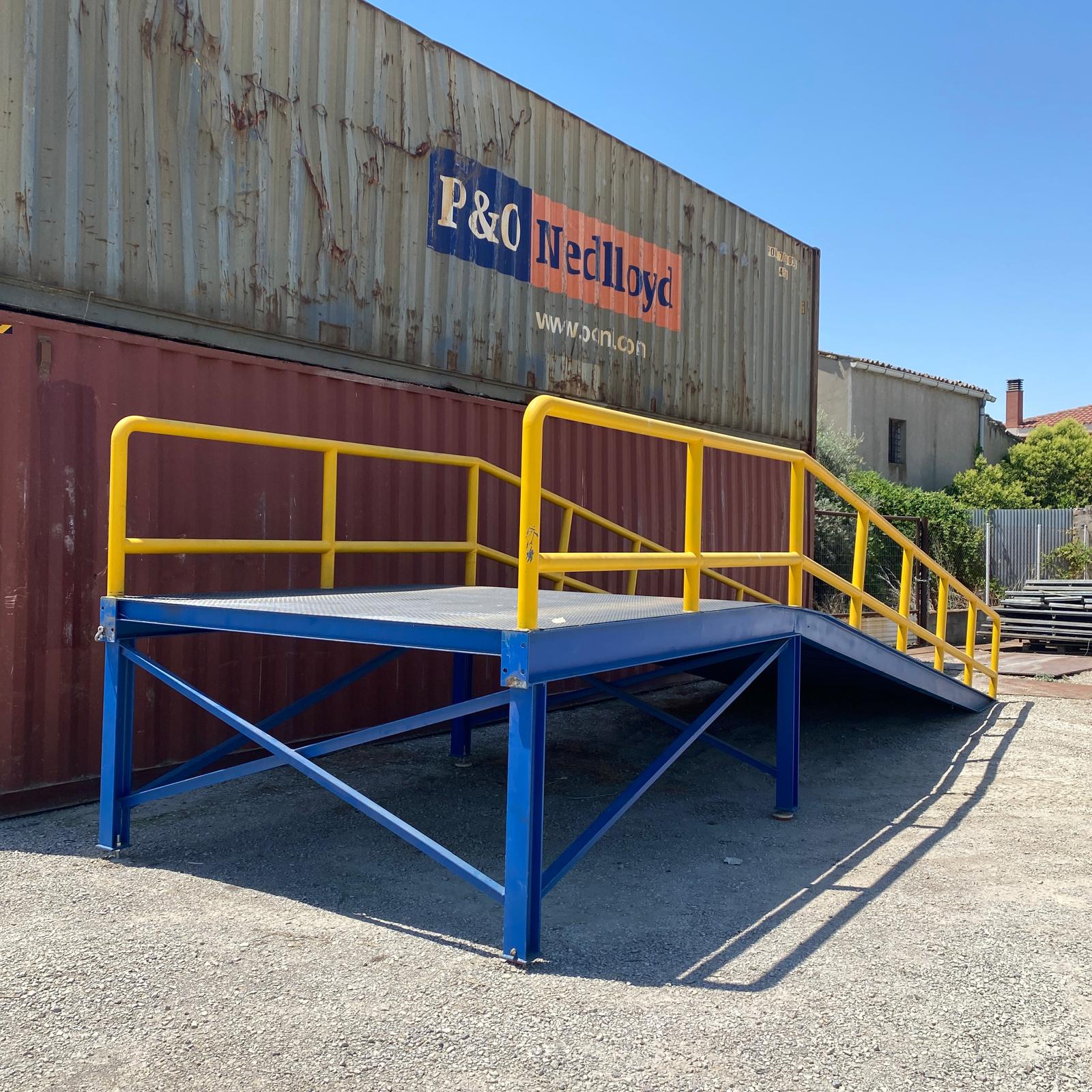 rampa metálica industrial con plataforma de carga y barandillas