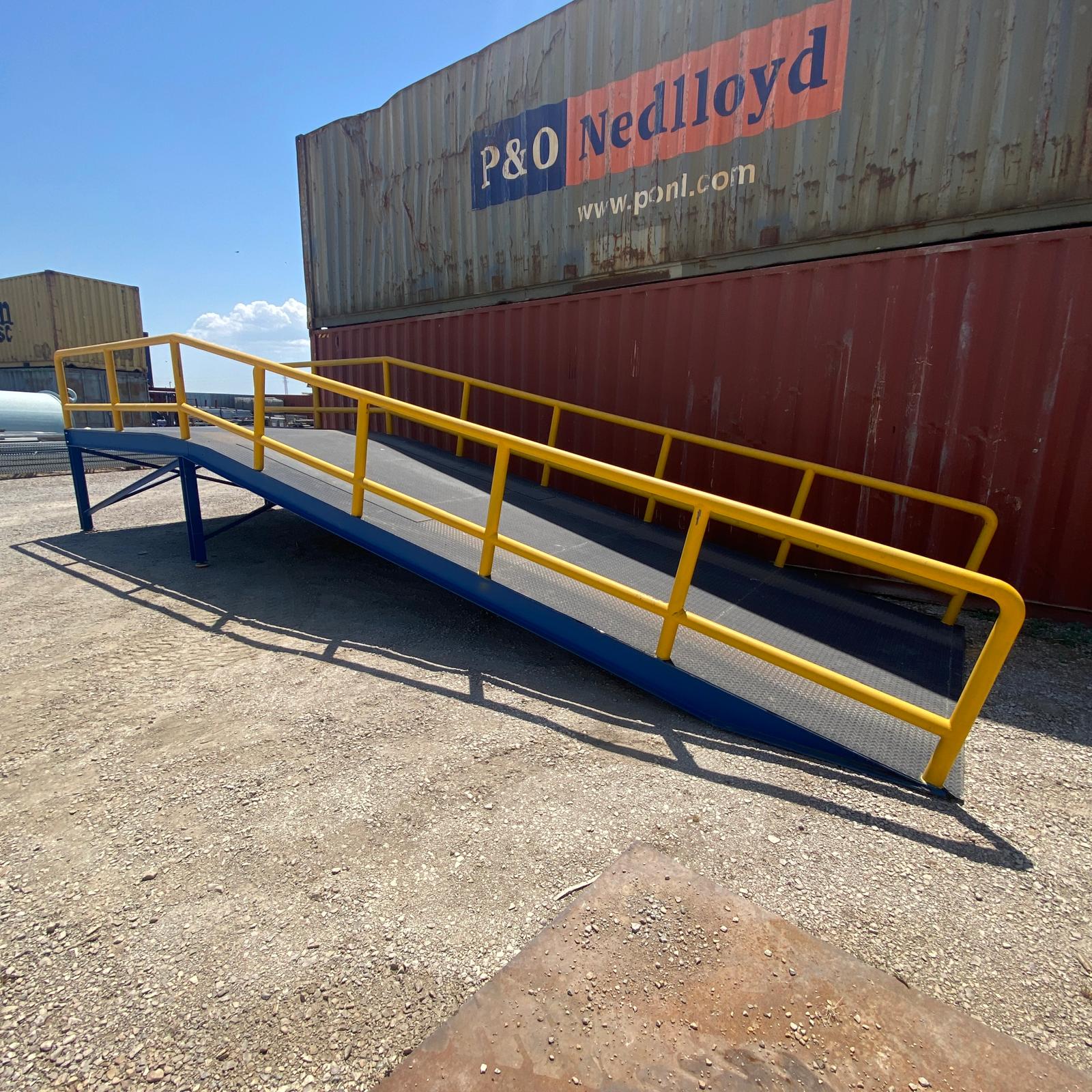 rampa metálica industrial con plataforma de carga y barandillas