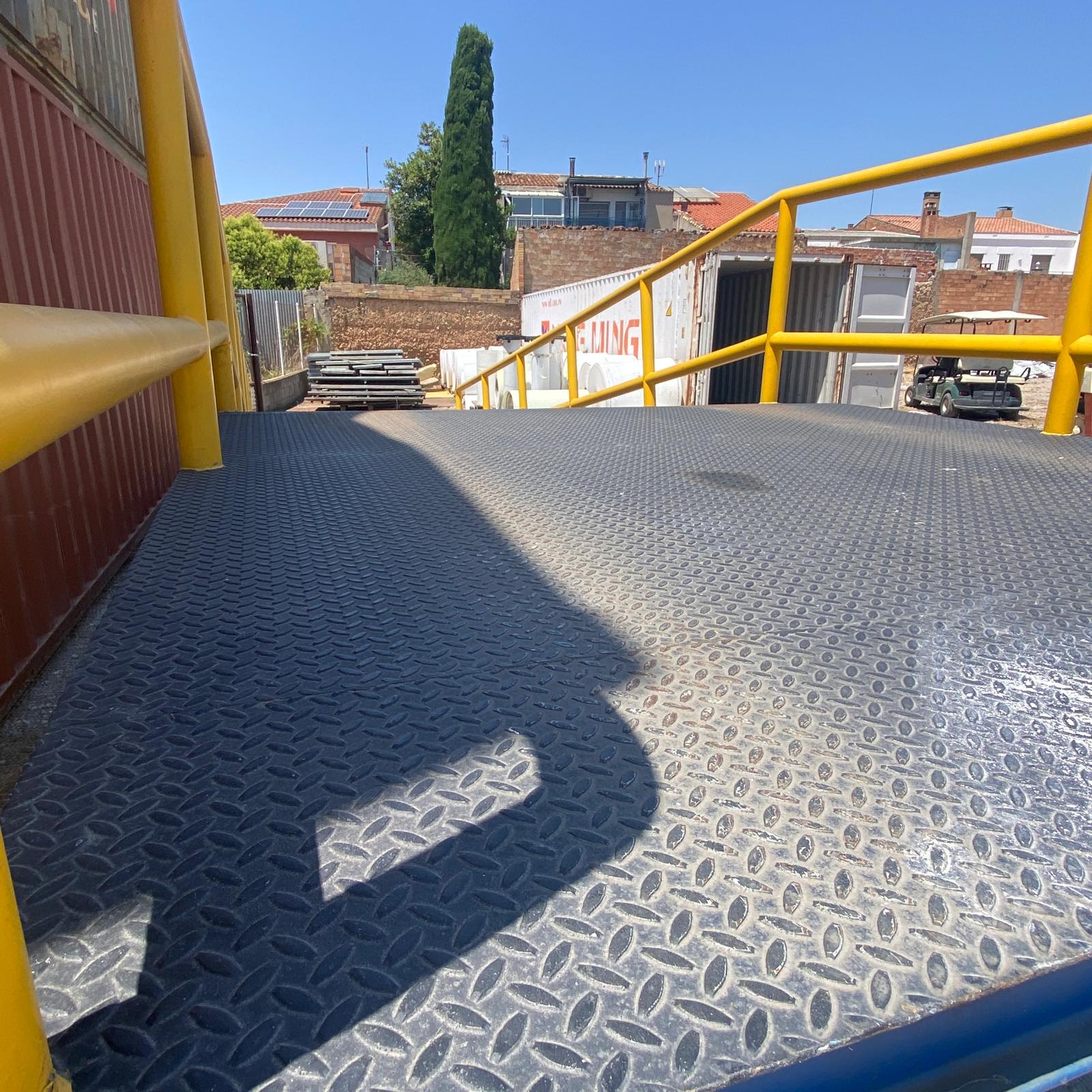 rampa metálica industrial con plataforma de carga y barandillas